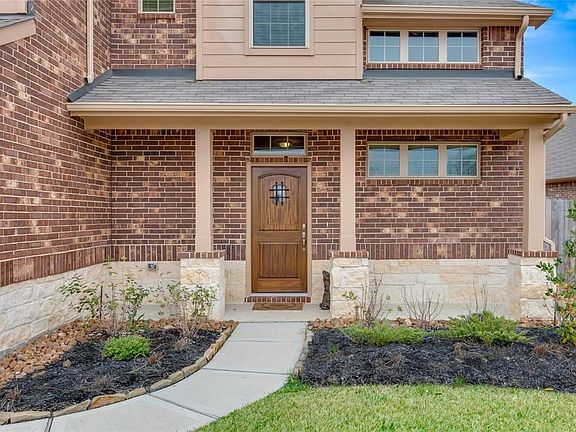 Covered front porch with gorgeous stained front door.