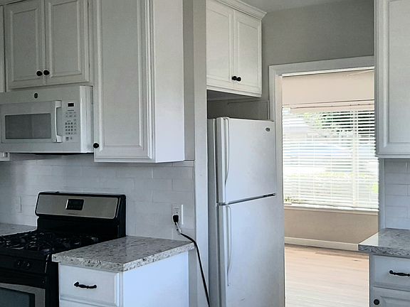 Kitchen showing Refrigerator, Stove, Microwave & Sink leading into Formal Dining Area & Living room