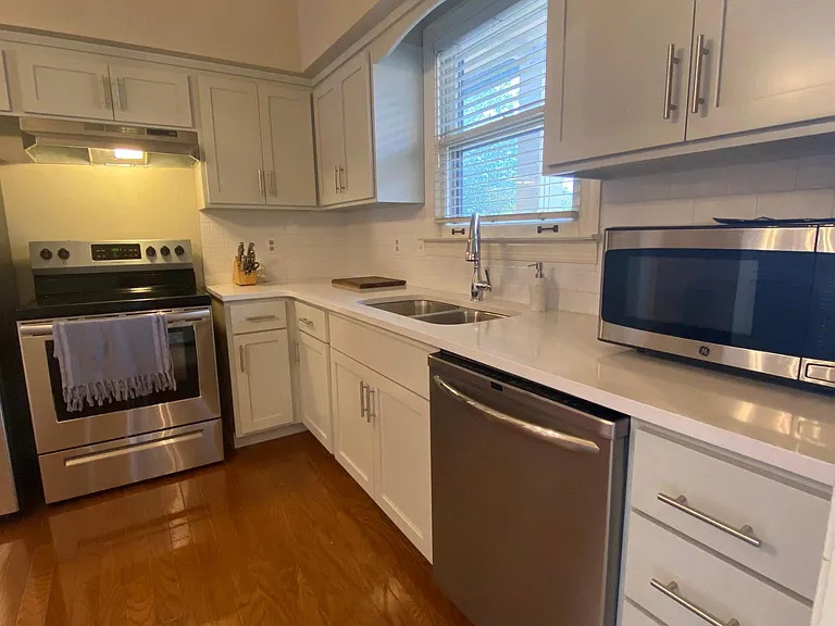 Brand new kitchen with new appliances, light gray soft-close cabinets, quartz countertops and tile backsplash