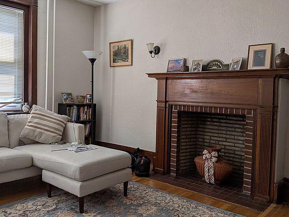 Large living room overlooking Main St with an ornamental, original fireplace