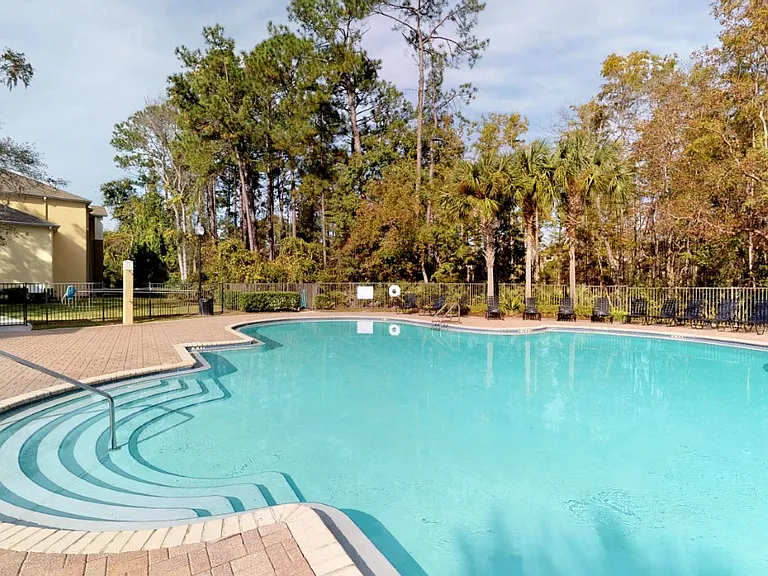 Large pool with lush trees at Gregory Cove in Jacksonville, FL