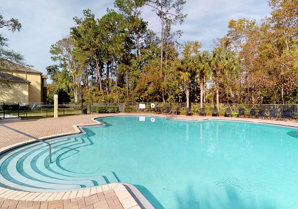 Large pool with lush trees at Gregory Cove in Jacksonville, FL