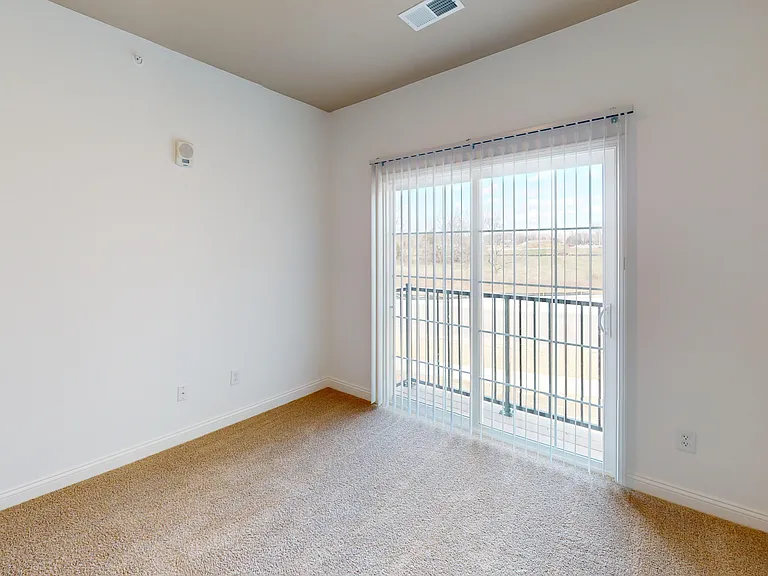 The Pyle floor plan's bedroom features lush carpeting with a sliding glass door that leads to a juliet balcony. The Pyle floor plan's bedroom features lush carpeting with a sliding glass door that leads to a juliet balcony.