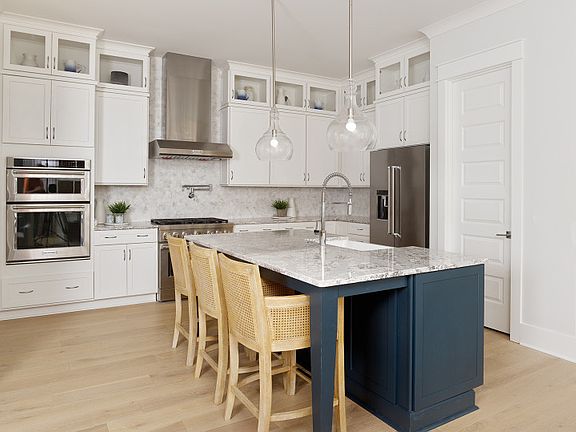 This cooks Kitchen features KitchenAid appliances including a double wall oven, and gas range with s