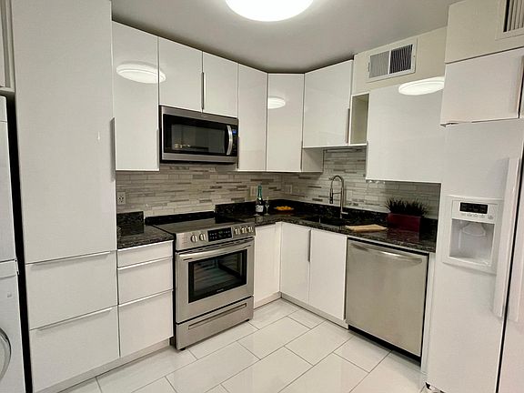 Beautiful new white kitchen with Washer & Dryer. Has a back door exit.