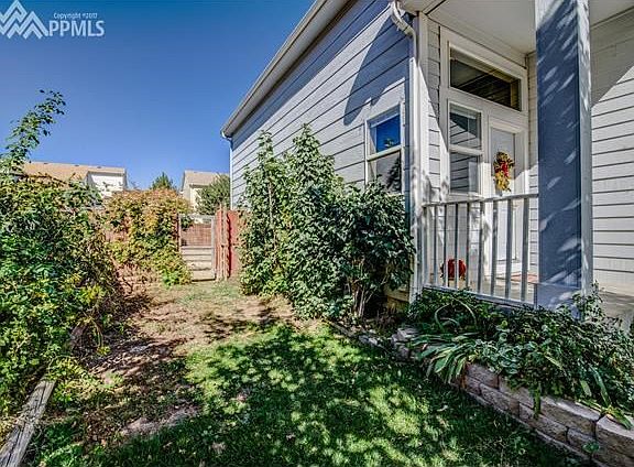 Beautiful and lush flowering lilac bushes and climbing roses accent the side of the home by the front door.