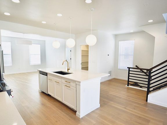View from dining nook to kitchen island, large walk-in pantry and living room.