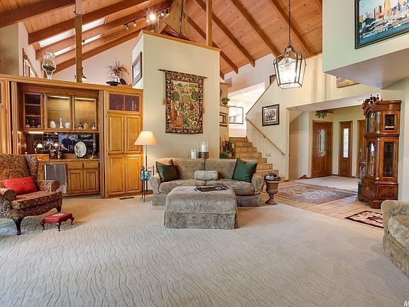 Skylights in the kitchen ceiling offer additional natural light to the interior. There are numerous areas to display your art and collectibles. A wetbar is tucked into the living room built-ins. The staircase seen here leads to the kitchen and dining room