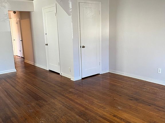 Living room, view of the hallway and closets, and basement door