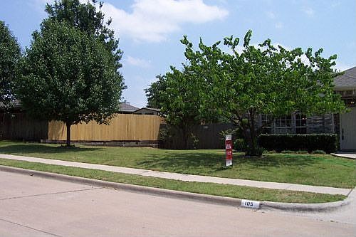 Large front/side yard with brand new fence on the retaining wall.