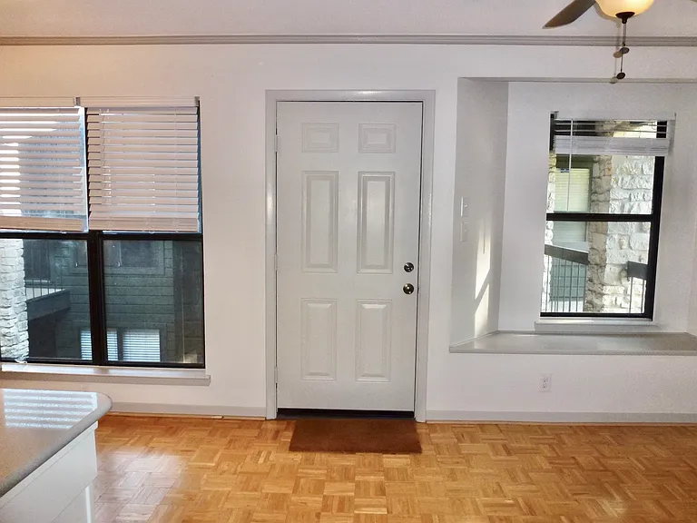 Wood floor, window seat, windows look down on courtyard.