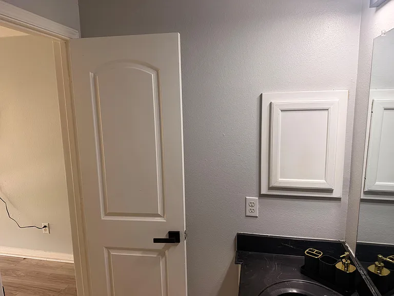 Bathroom vanity area with black countertop, undermount sink, framed mirror, and updated hardware for easy daily routines.