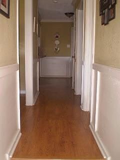 Hall way downstairs with wood laminate flooring.