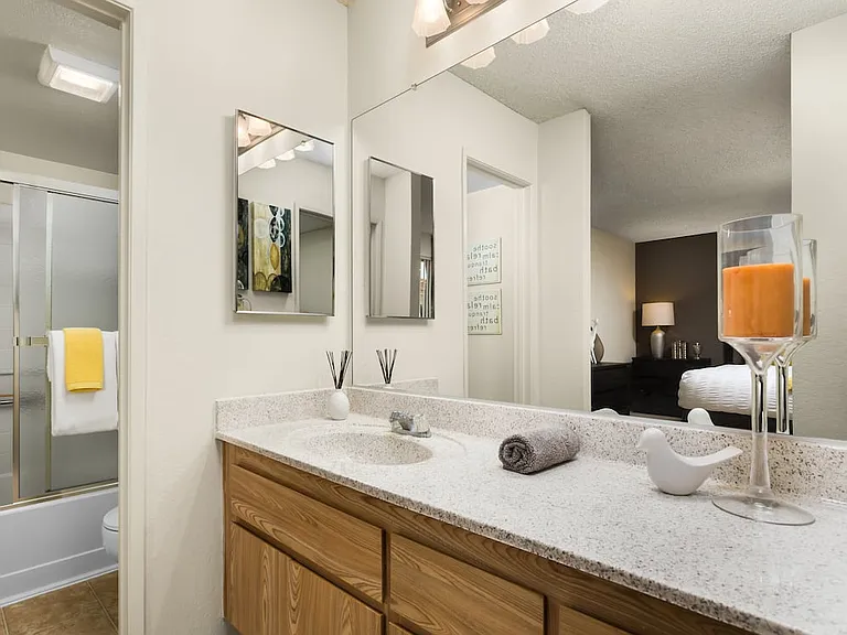 Classic Package bath with oak cabinetry, white speckled granite countertop, and tile flooring