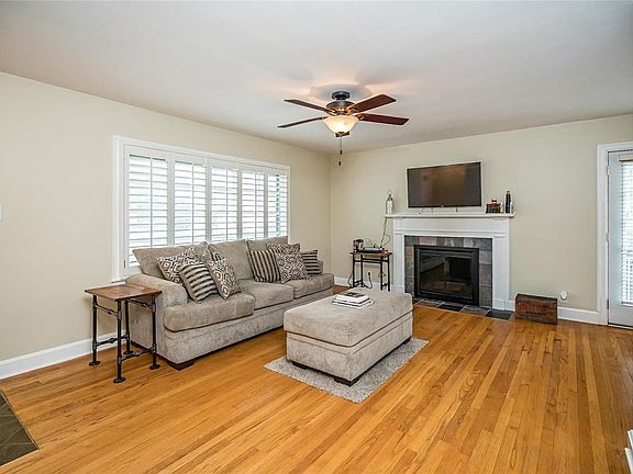 Living Room has wood burning fireplace, plantation shutters, and original hardwood floors!