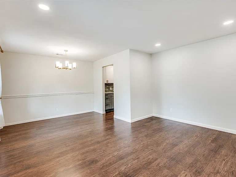 Spacious interior with wood-finish flooring, recessed lighting, and a modern chandelier