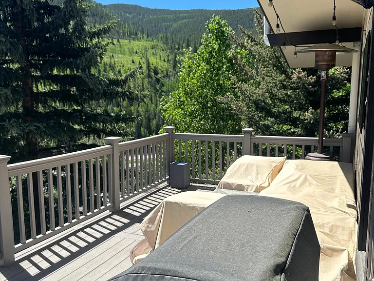 Large deck facing Vail mountain with outdoor furniture and a BBQ grill.