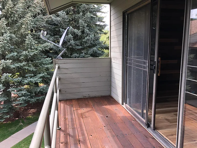 Cozy deck runs the width of the Master Bedroom and overlooks the beautiful mature grounds of the common area below.