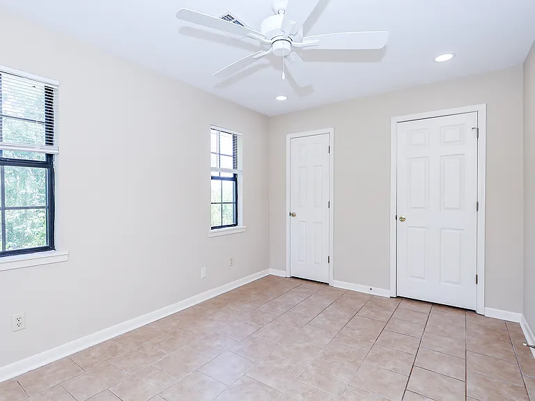 Bedroom with view toward door to walk-in closet (left) and bathroom (right).