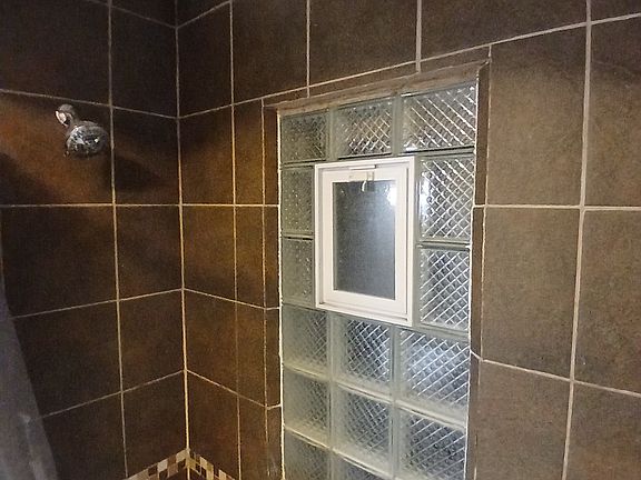 Tiled bathroom with deep tub.