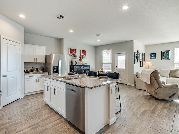 Light and bright kitchen with stainless appliances, granite countertops, and walk in pantry