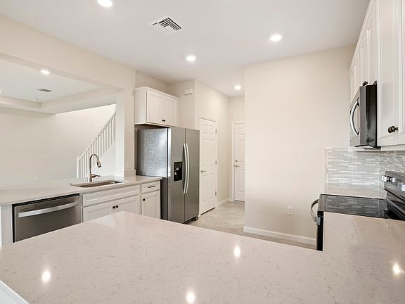 Kitchen with quartz countertops and decorative backsplah
