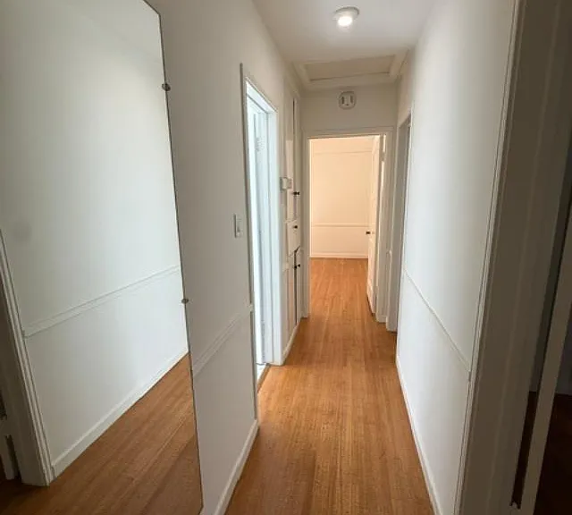 Hallway separating two bedrooms.