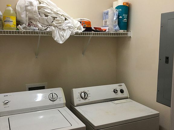Laundry room with washer and dryer and breaker panel.