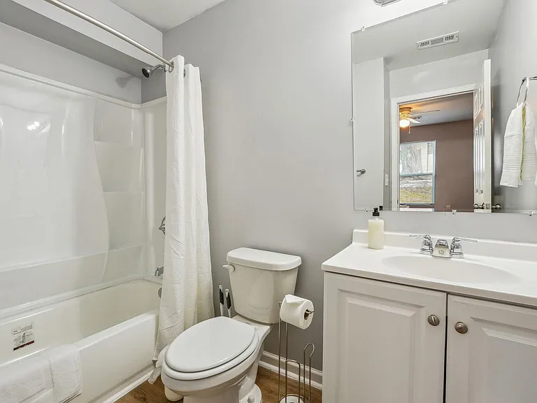 Full bathroom with tub/shower combo, single-sink vanity, mirror, and towel storage for everyday convenience.