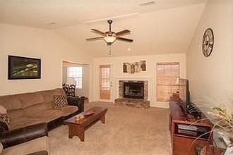 This shows the fireplace (not for building fires--just for decoration). But it is a pretty highlight to the room. The window treatments throughout the home are nice white blinds--always a clean look.