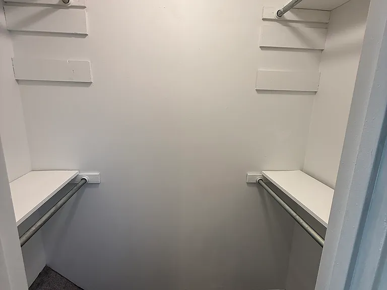 Walk-in closet with four (4) shelves and four (4) poles