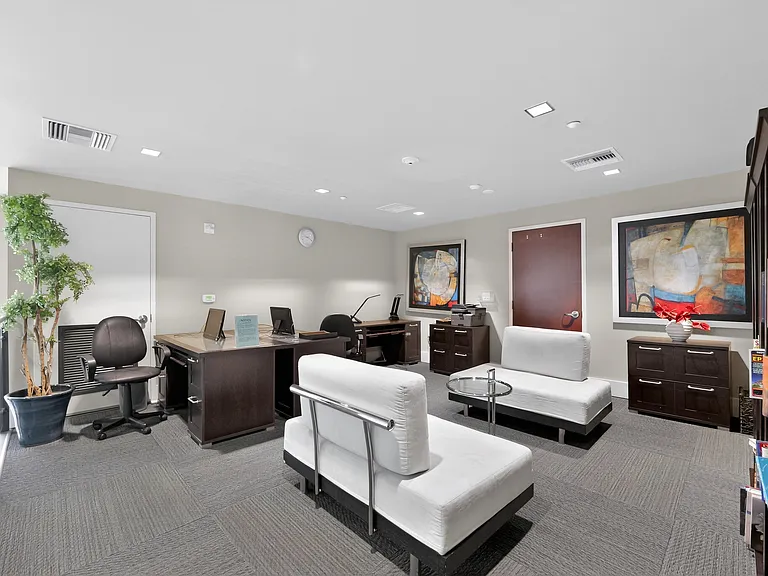 Resident business center/lounge with Wi-Fi, workstations, seating, and bookshelves with books.