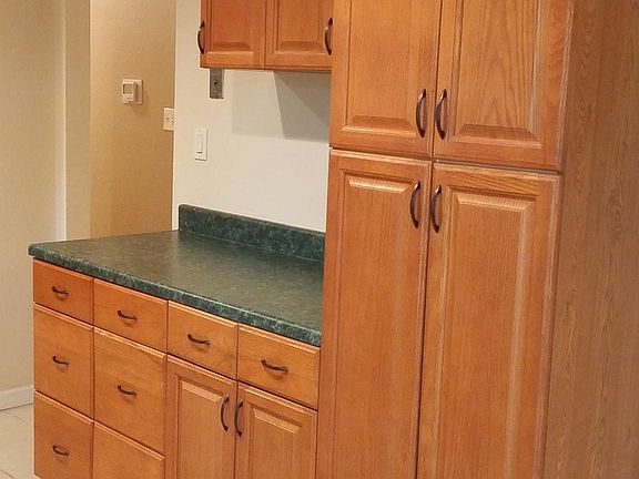 The counter top is no longer green. It is the same grey/white as by the sink.