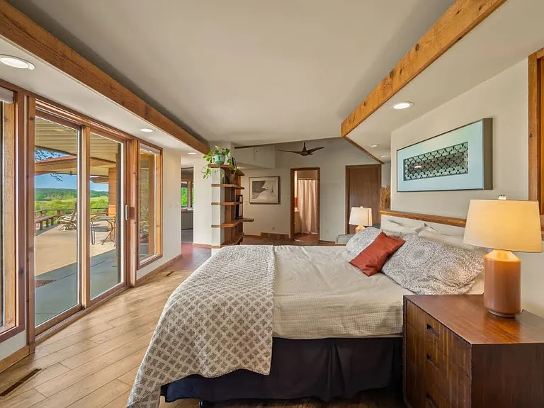 A spacious and serene master suite with sliding doors that open to the patio, offering breathtaking views and plenty of natural light.