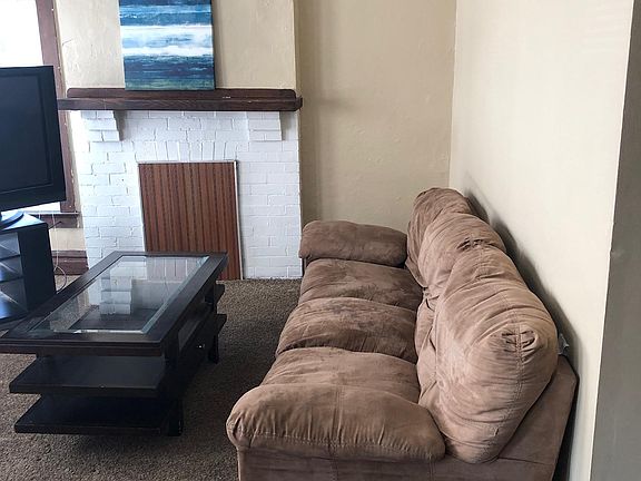 Living room with 2 sofas and 1 TV. Newer carpeting with no staining. Living room has a closet for storage.