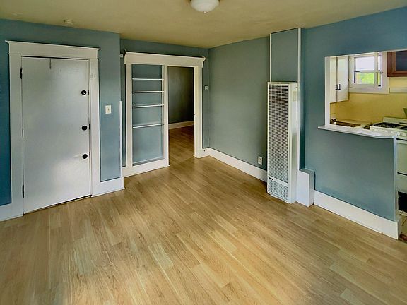 Living room with built in shelfs, AC, front door on left