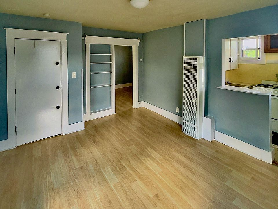 Living room with built in shelfs, AC, front door on left