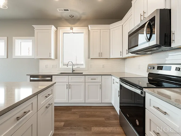 Beautiful kitchen into an open living space. (Photo of another unit with similar finishes and quality.)