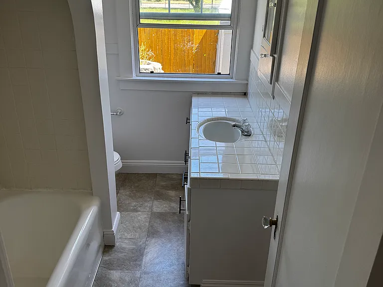 Bathroom with bathtub and shower combo and a spacious sink vanity
