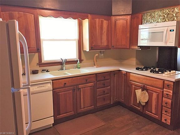 Updated cherry and Corian topped kitchen w/gas cook top, built-in dishwasher and microwave plus new in 2016 laminate wood floors.