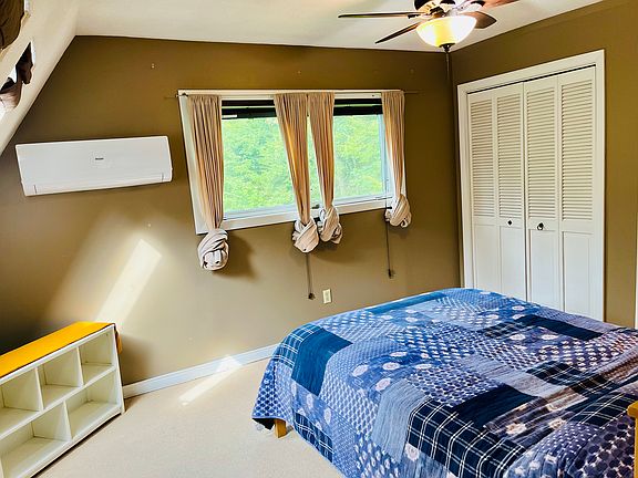 View of the bedroom showing the windows across from the bed.