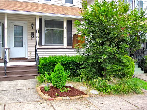 Front with Japanese maple tree and other landscaping and full-width roofed front porch! Welcome!