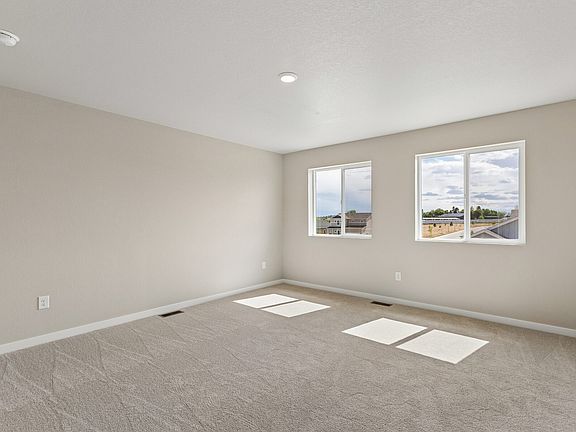 The master bedroom is spacious with large windows.
