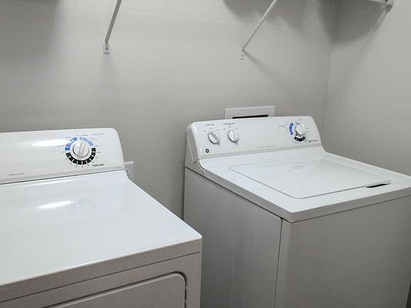 An in-unit washer and dryer with shelves at Amber Ridge Apartments in Fargo ND