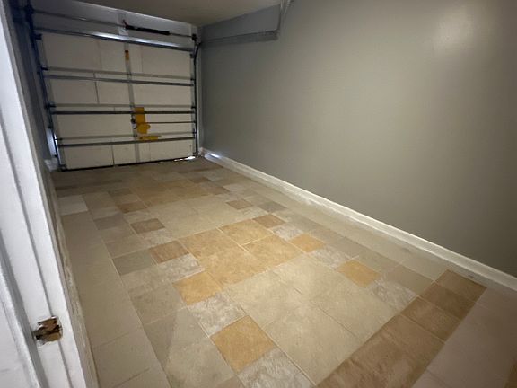 One car garage equipped with a ceiling fan and lighting