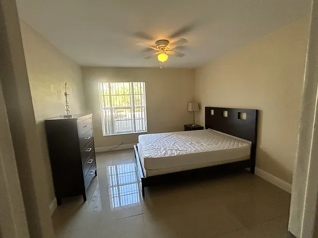 full view of bedroom which now has two nightstands, desk and office chair