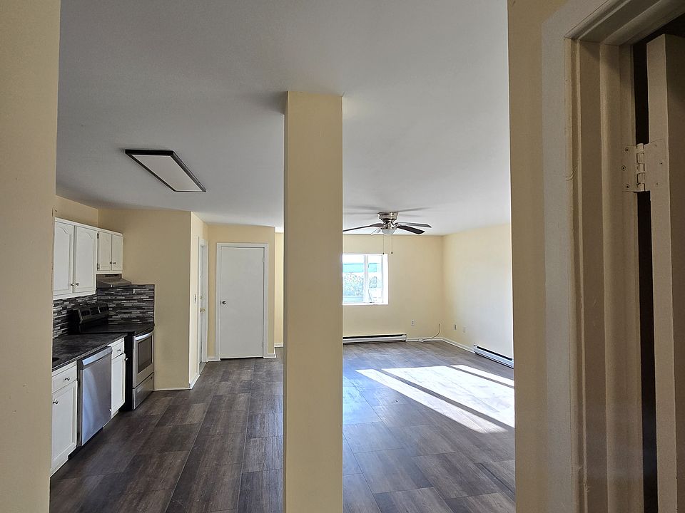 Living room and kitchen from rear hallway. Guest bedroom door is on the right
