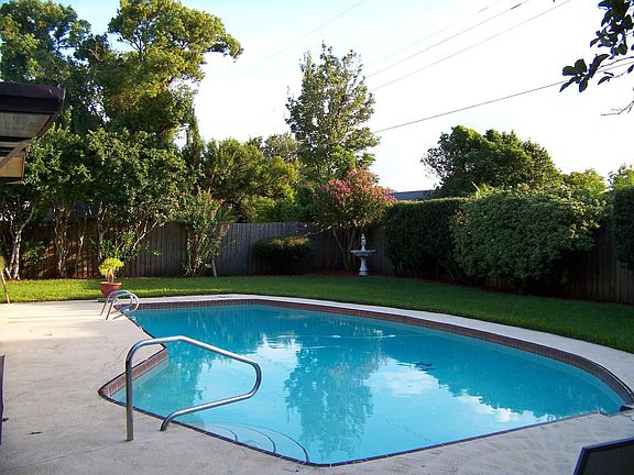 View of backyard and pool from north side of property