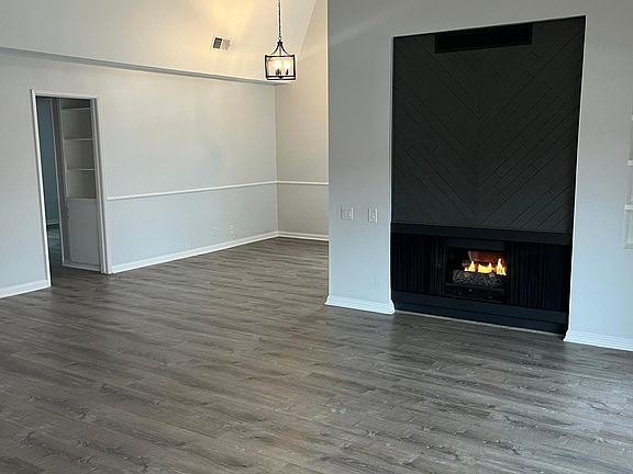 Living area with new floors, light fixtures, easy-on fireplace, vaulted ceilings