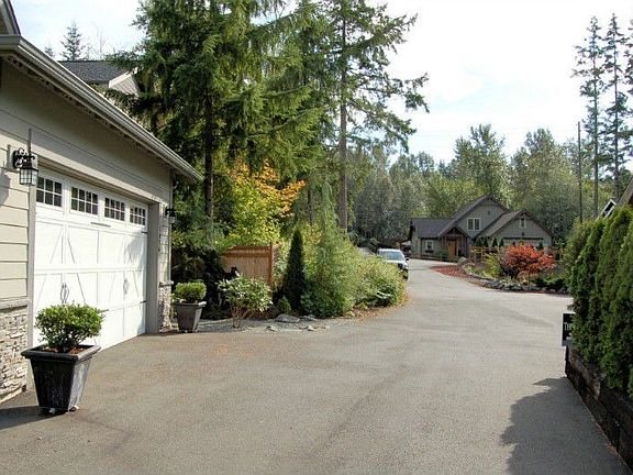 Secluded setting at end of dead-end road, adjacent to trees and pond.